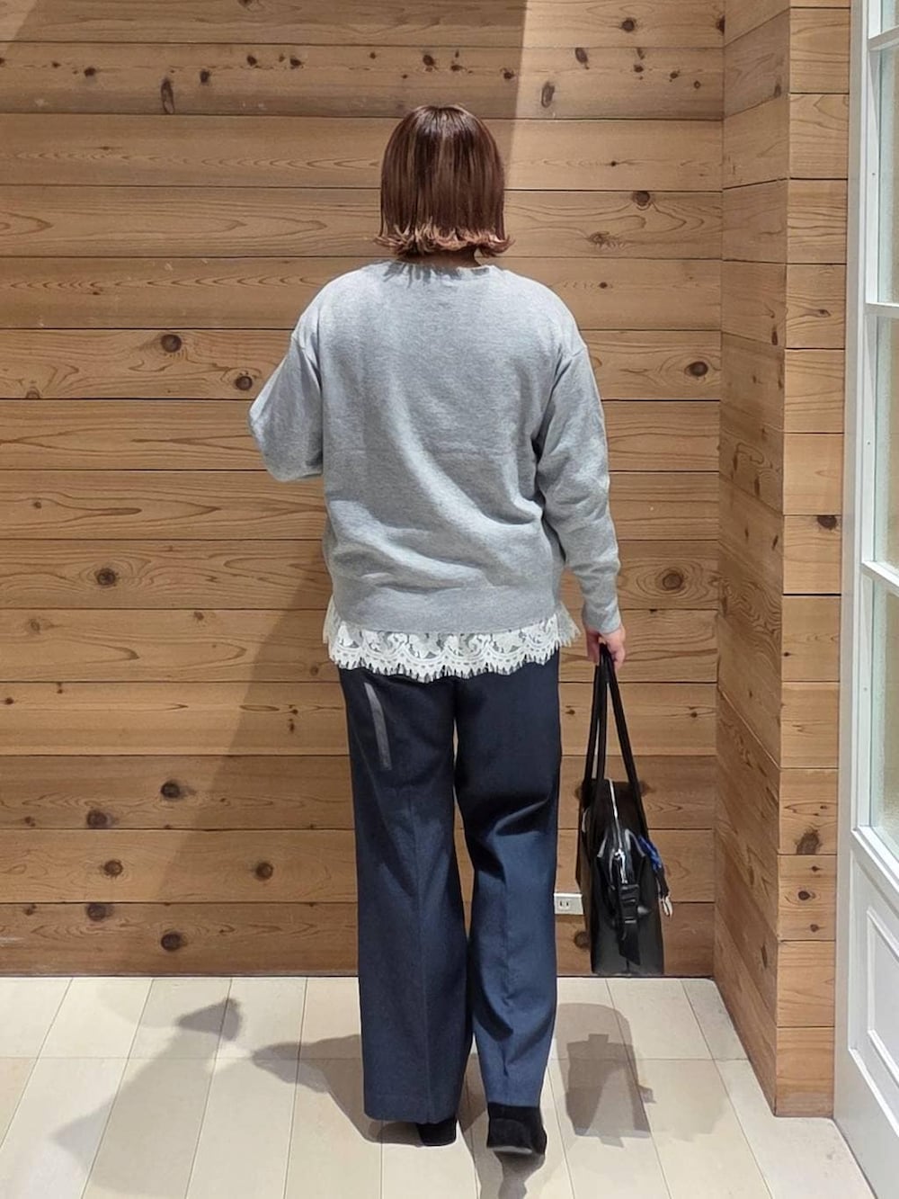 ブラック系のボストンバッグ、ブラック系のブルゾン、ブルー系のその他パンツを着用したレディースの冬コーディネートの3枚目の写真