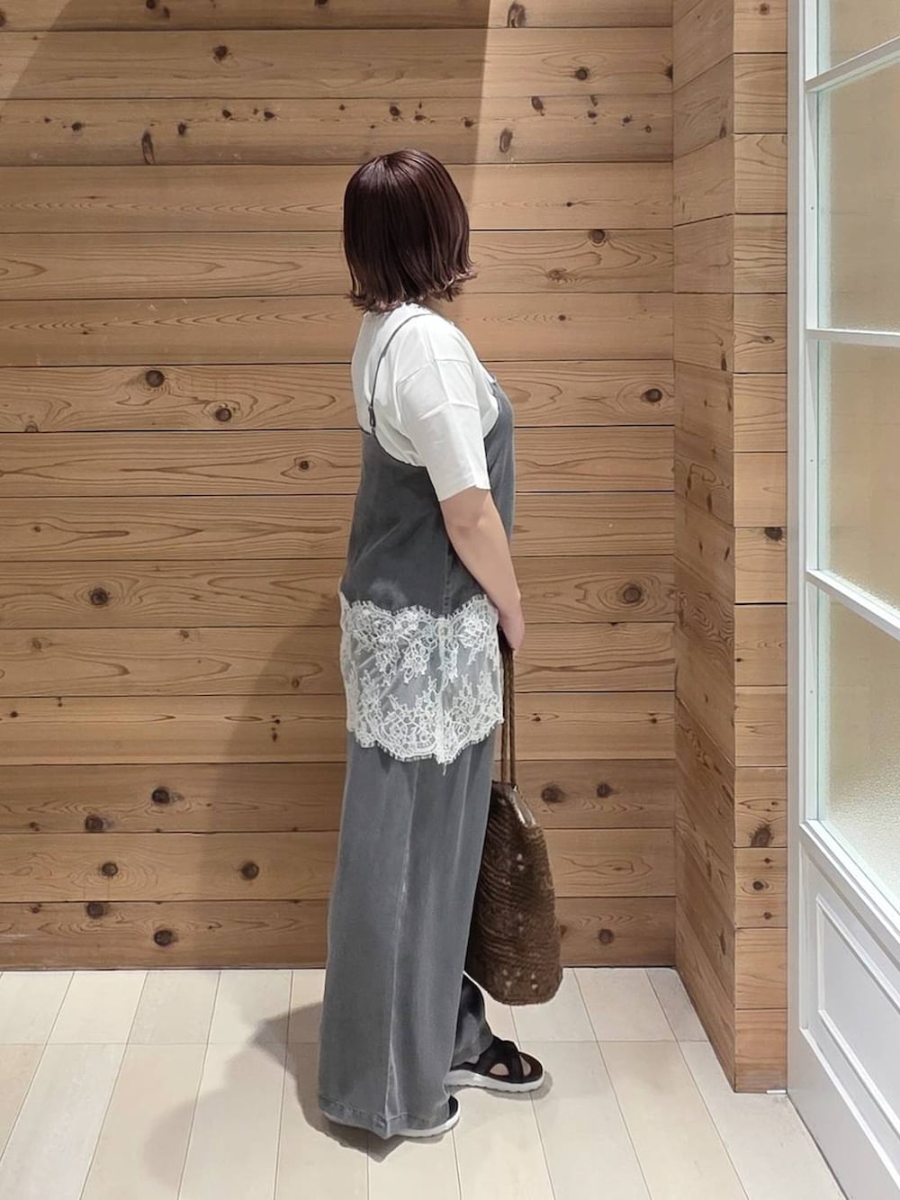 ホワイト系のTシャツ/カットソー、ブラック系のデニムパンツ、ブラウン系のトートバッグを着用したレディースの春コーディネートの2枚目の写真