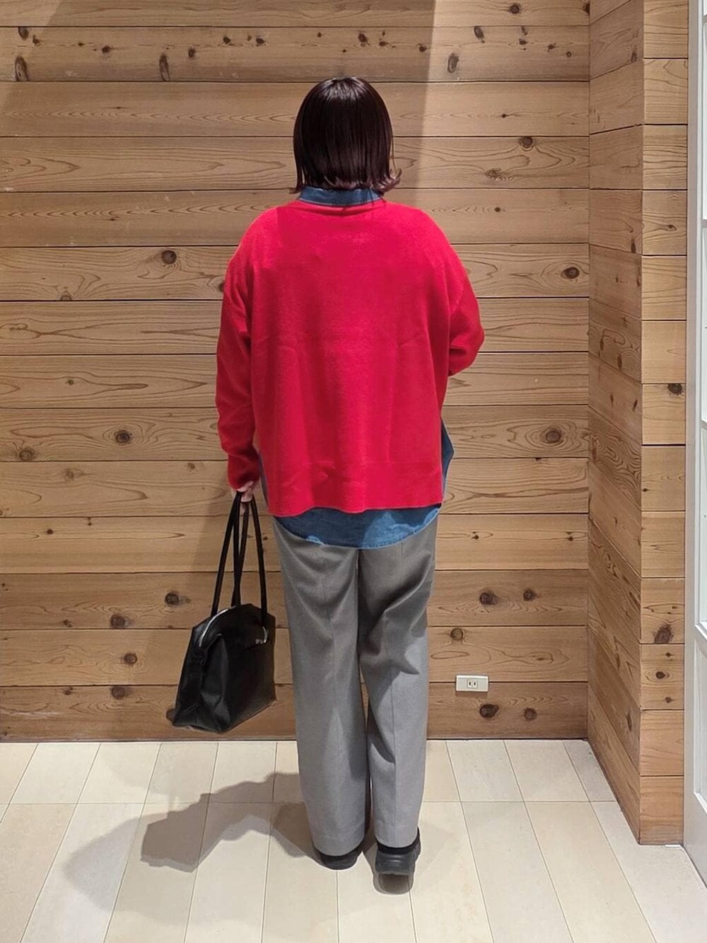 ブラック系のダウンジャケット/コート、ブラック系のボストンバッグ、ブルー系のシャツ/ブラウスを着用したレディースの冬コーディネートの3枚目の写真