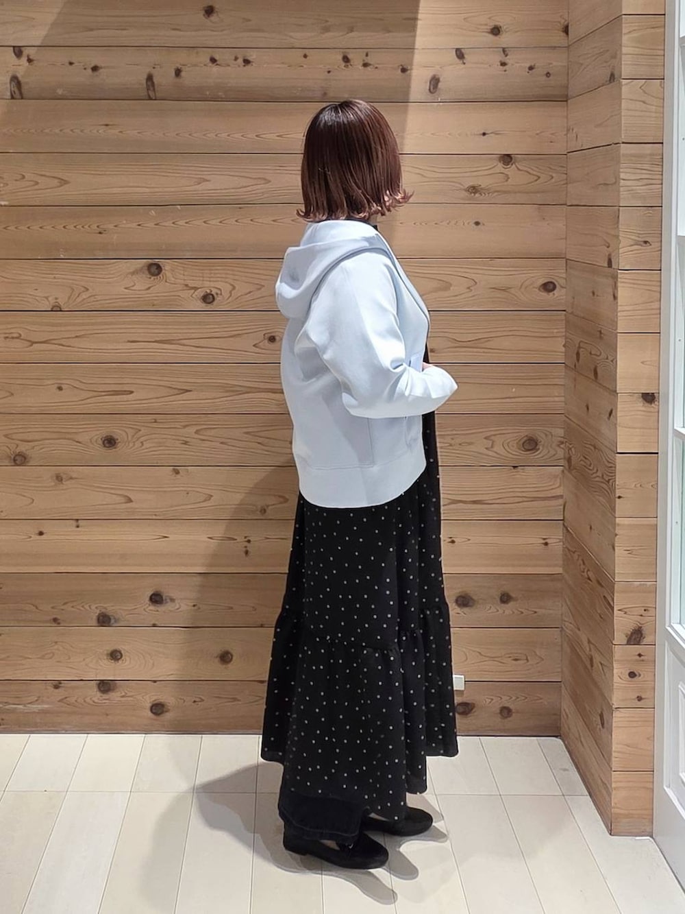 ブラック系のローファー、ブラック系のショルダーバッグ、ブルー系のデニムパンツを着用したレディースの春コーディネートの2枚目の写真