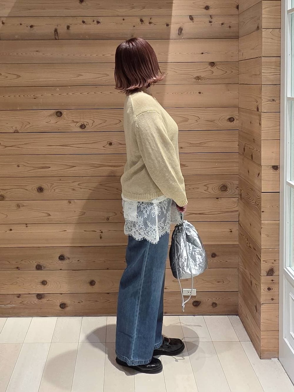 ブラック系のローファー、ブルー系のデニムパンツ、シルバー系のハンドバッグを着用したレディースの春コーディネートの2枚目の写真