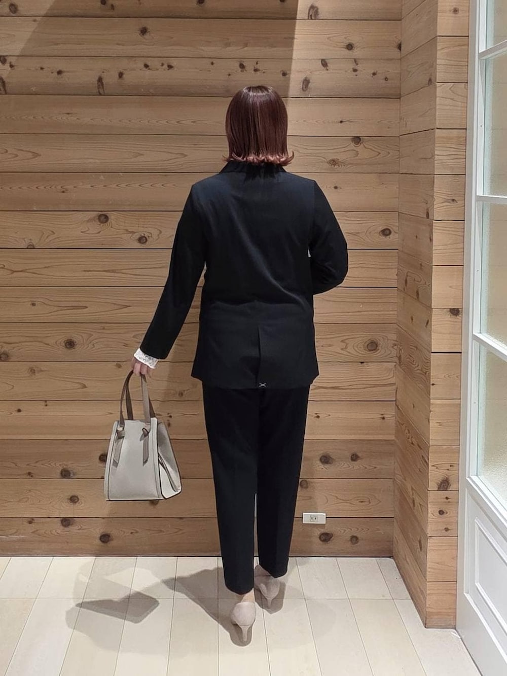 ホワイト系のショルダーバッグ、ホワイト系のパンプス、ホワイト系のTシャツ/カットソーを着用したレディースの冬コーディネートの3枚目の写真