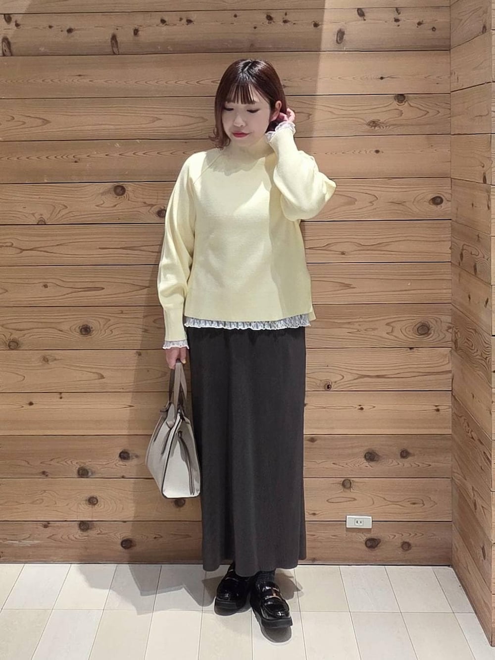 ブラック系のローファー、ホワイト系のショルダーバッグ、ホワイト系のTシャツ/カットソーを着用したレディースの冬コーディネートの4枚目の写真