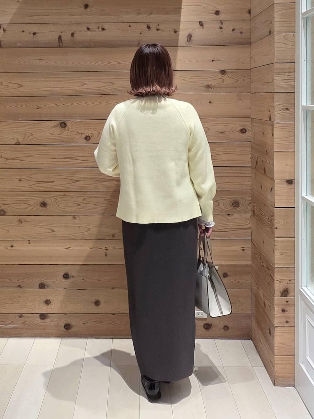 ブラック系のローファー、ホワイト系のショルダーバッグ、ホワイト系のTシャツ/カットソーを着用したレディースの冬コーディネートの3枚目の写真