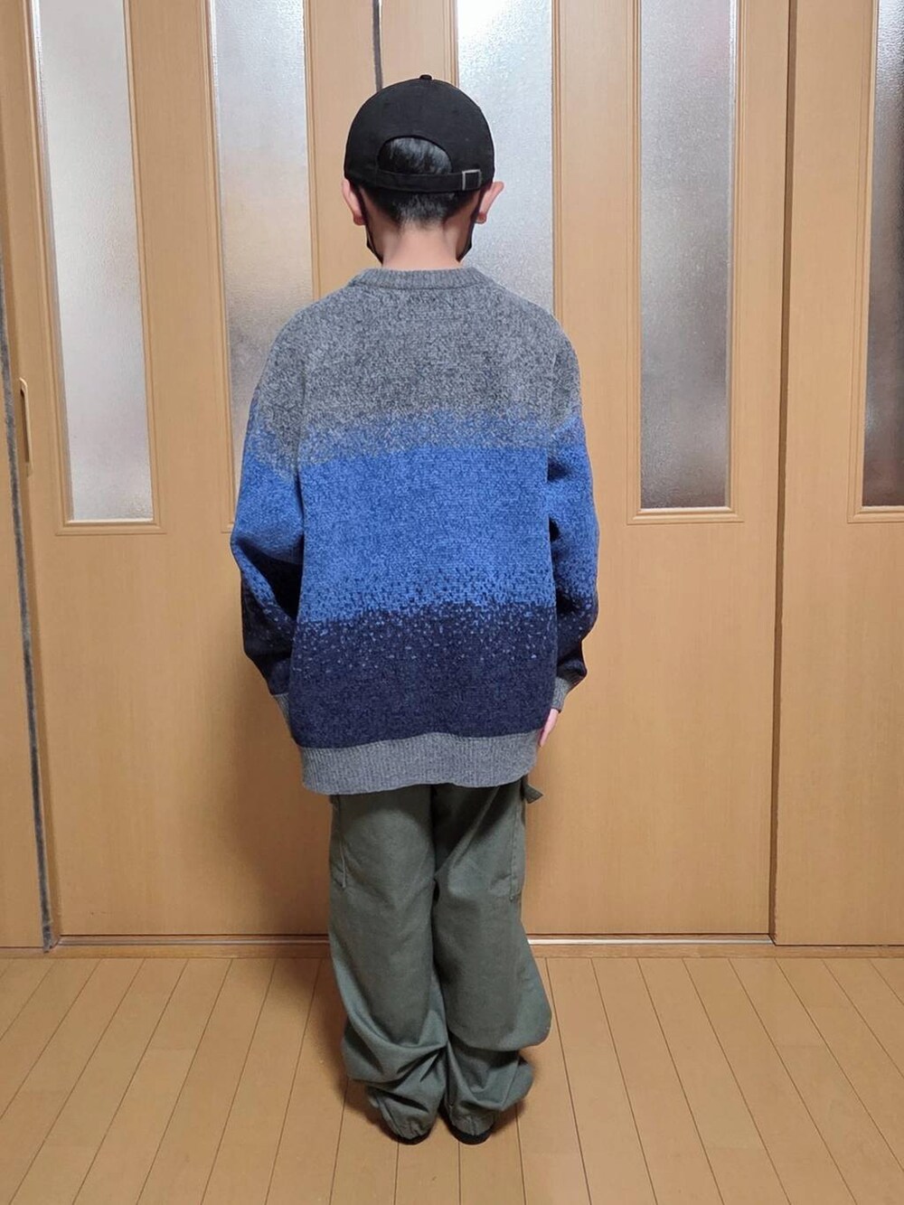 ベージュ系のブルゾン、グリーン系のカーゴパンツ、グレー系のニット/セーターを着用したキッズの冬コーディネートの4枚目の写真