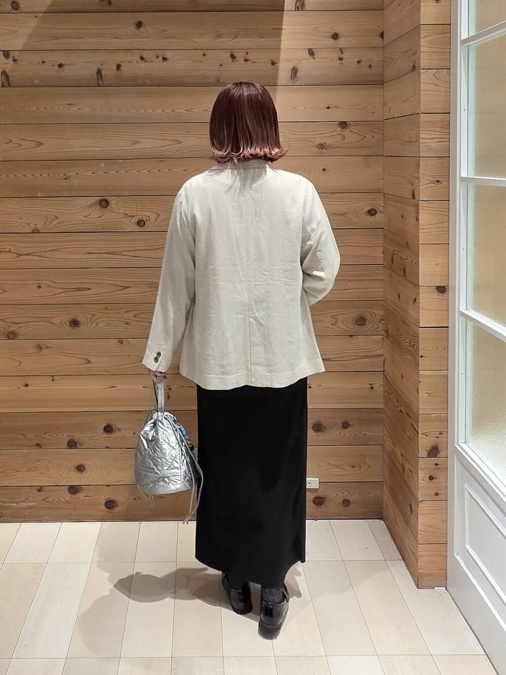 ブラック系のローファー、シルバー系のハンドバッグ、ブラック系のスカートを着用したレディースの春コーディネートの3枚目の写真