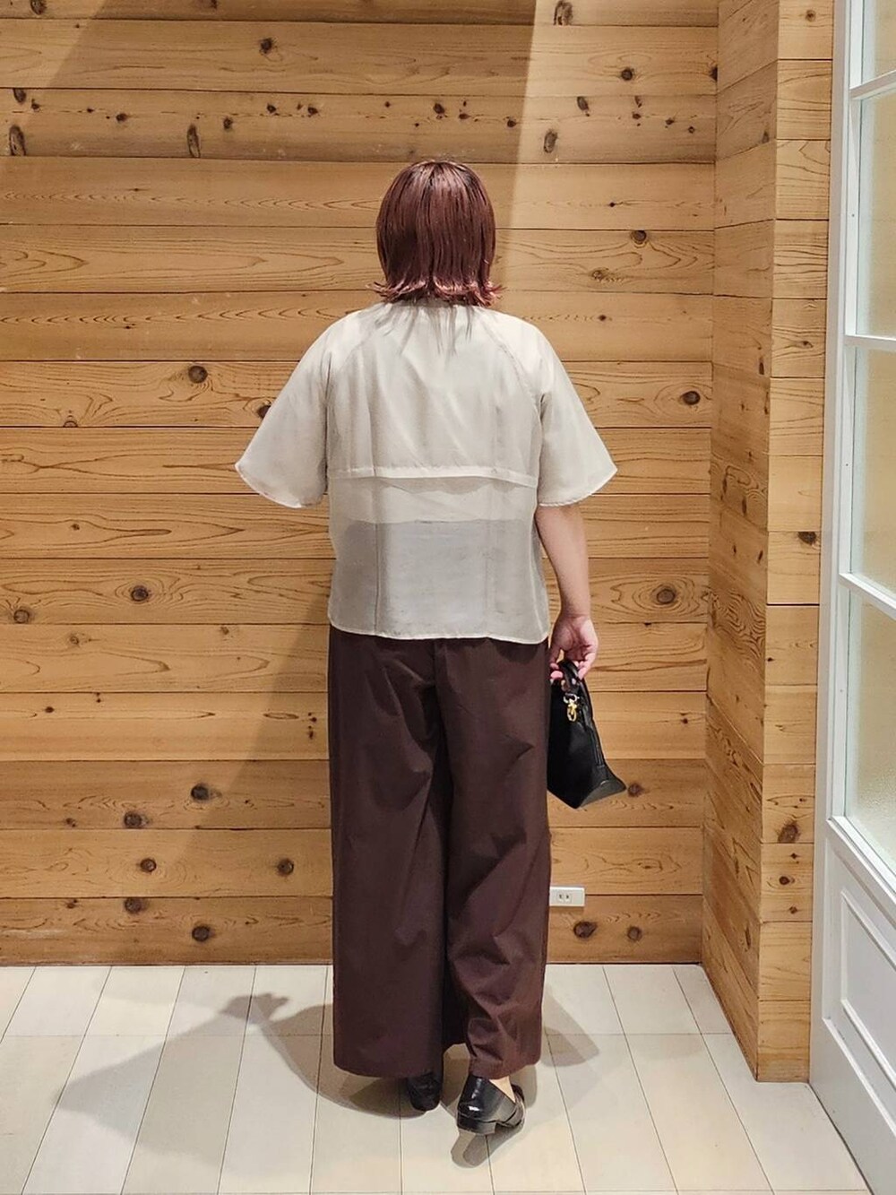 ブラック系のショルダーバッグ、ベージュ系のTシャツ/カットソー、ブラック系のパンプスを着用したレディースの夏コーディネートの3枚目の写真