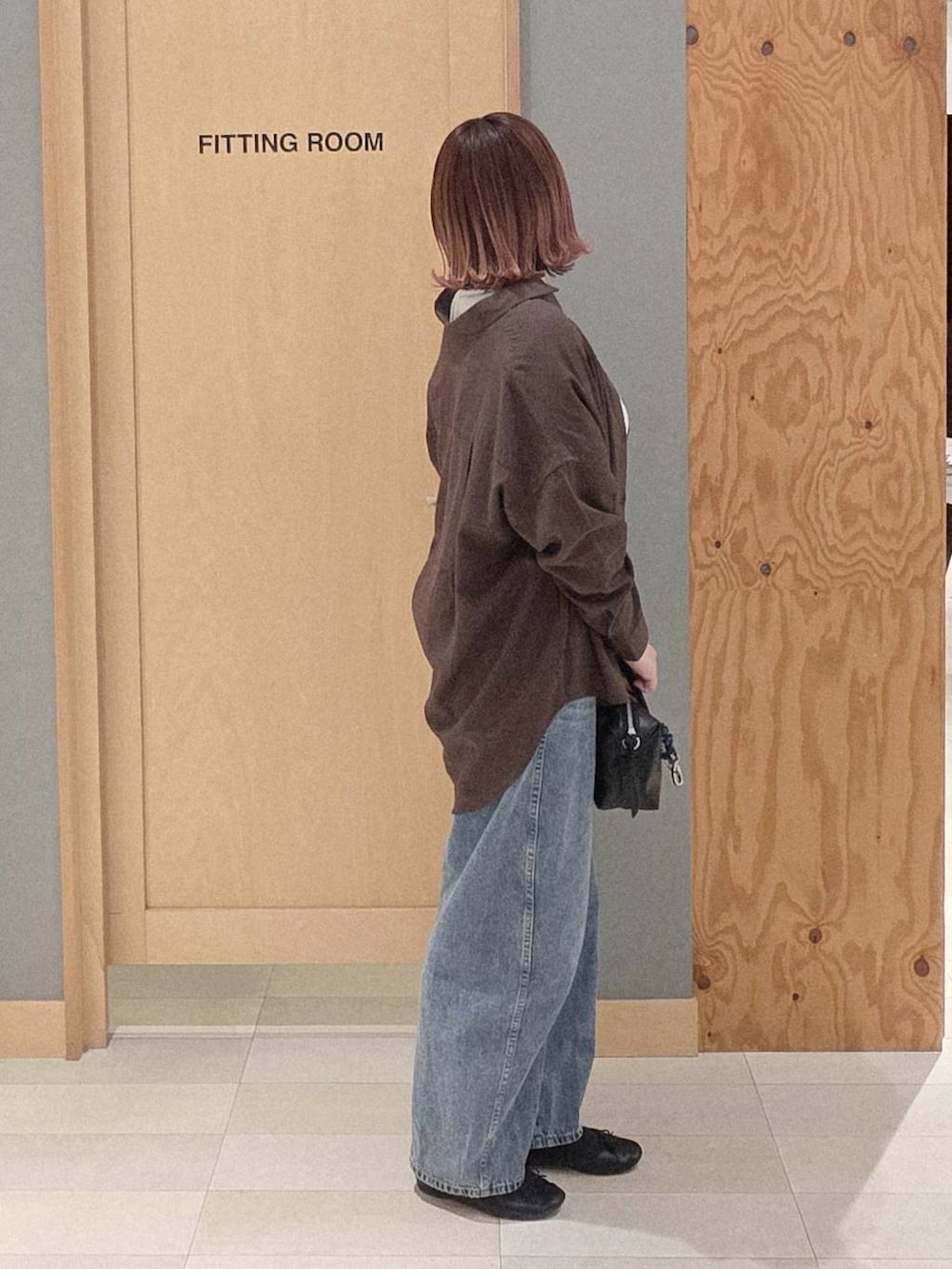ブラック系のバレエシューズ、ブルー系のデニムパンツ、ブラック系のボストンバッグを着用したレディースの春コーディネートの2枚目の写真