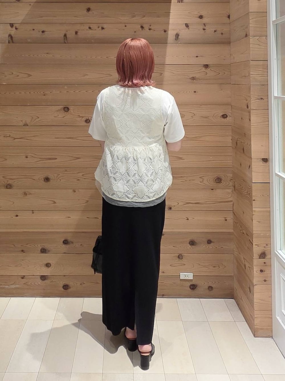 ブラック系のスカート、ホワイト系のTシャツ/カットソー、ブラック系のボディバッグ/ウエストポーチを着用したレディースの秋コーディネートの3枚目の写真