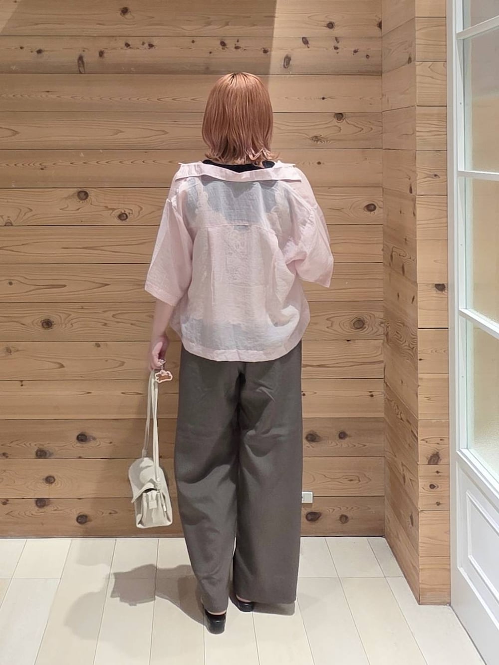 ベージュ系のショルダーバッグ、ピンク系のシャツ/ブラウス、ブラック系のタンクトップを着用したレディースの夏コーディネートの3枚目の写真