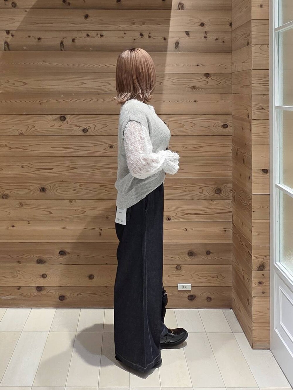 ホワイト系のカーディガン/ボレロ、ベージュ系のベスト、ブラック系のローファーを着用したレディースの秋コーディネートの2枚目の写真