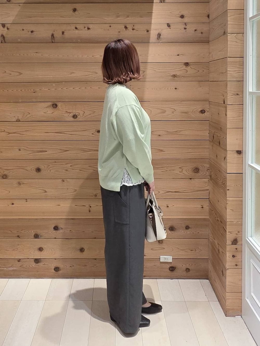 ブラック系のパンプス、ホワイト系のショルダーバッグ、ブラック系のマウンテンパーカーを着用したレディースの春コーディネートの2枚目の写真