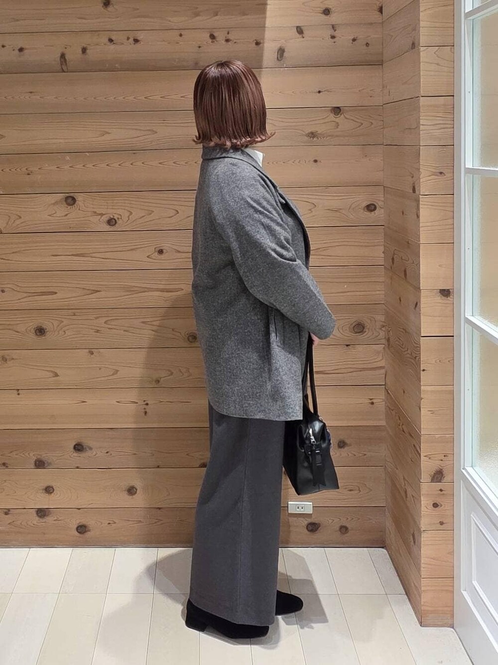 ブラック系のボストンバッグ、グレー系のチェスターコート、ホワイト系のシャツ/ブラウスを着用したレディースの冬コーディネートの2枚目の写真