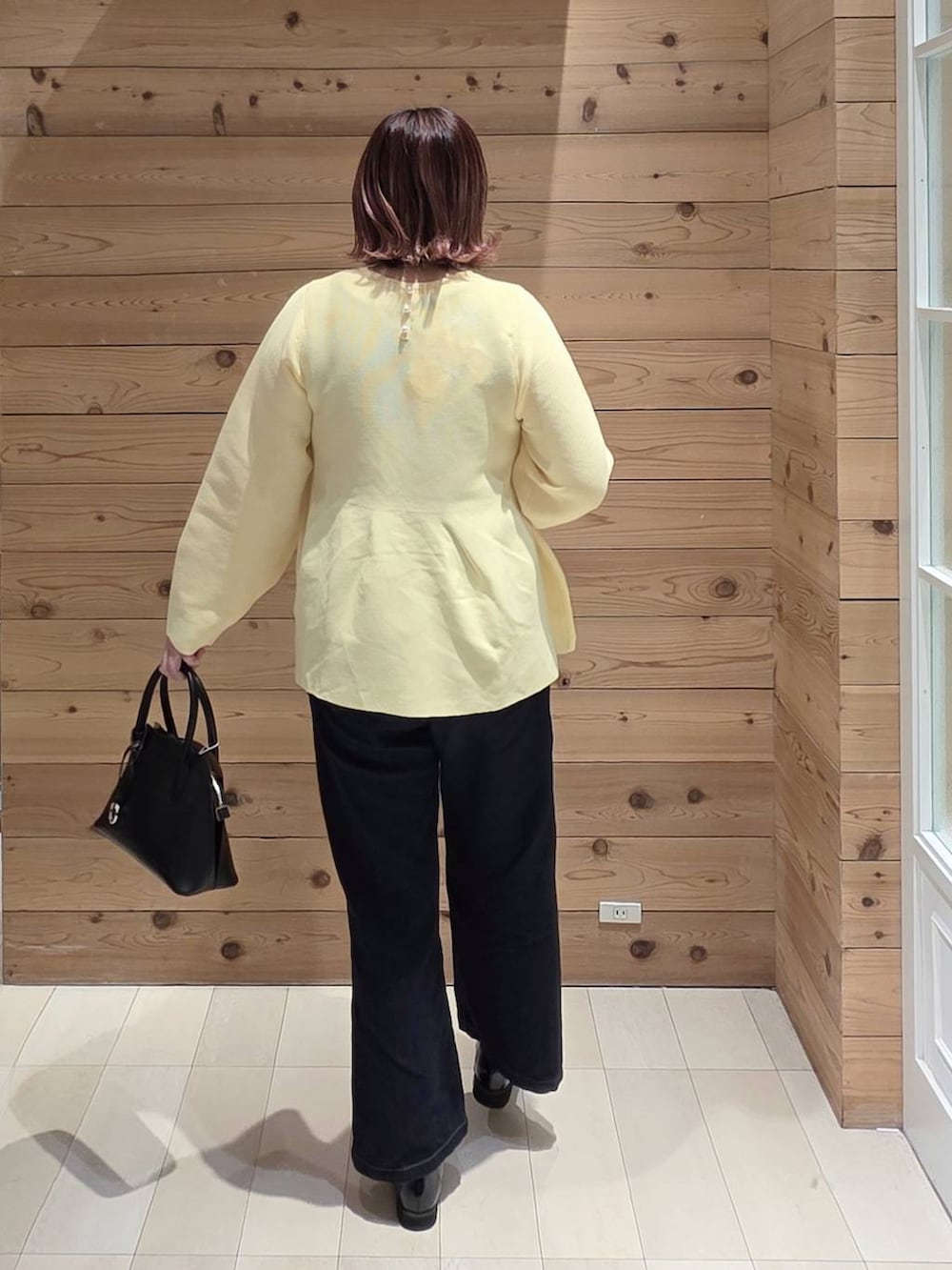 ブラック系のローファー、ブラック系のショルダーバッグ、ブルー系のデニムパンツを着用したレディースの冬コーディネートの3枚目の写真