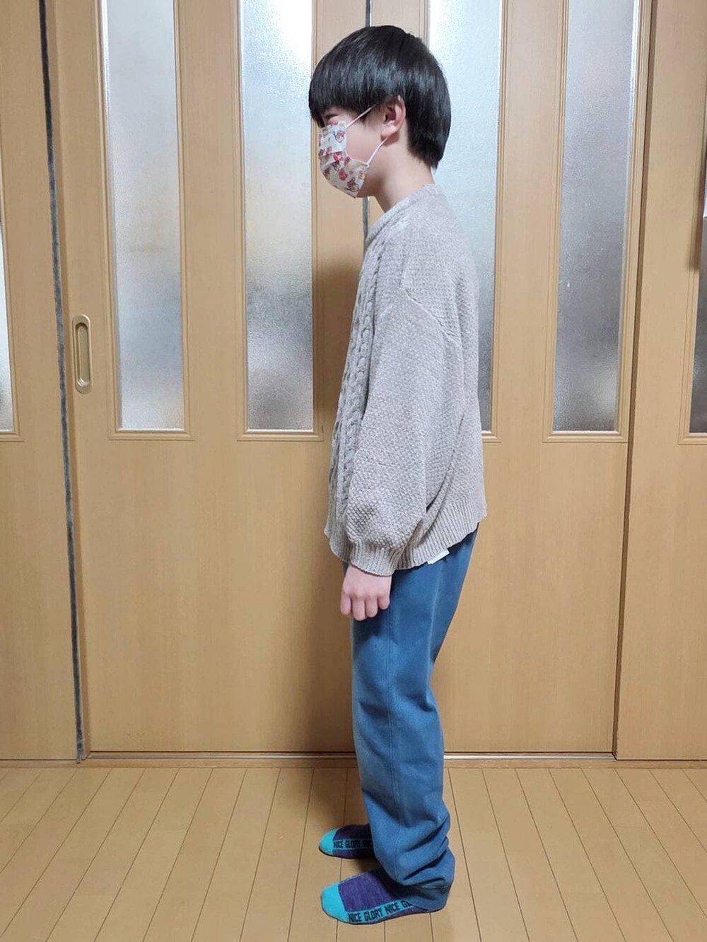 ベージュ系のニット/セーター、ブルー系のデニムパンツを着用したキッズの冬コーディネートの2枚目の写真