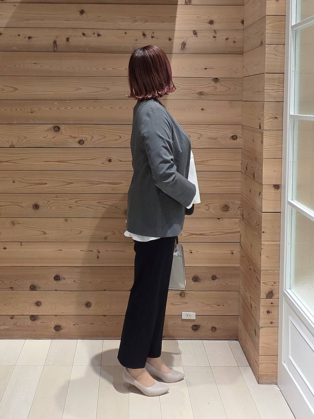 ホワイト系のショルダーバッグ、ホワイト系のパンプス、ブルー系のセットアップを着用したレディースの冬コーディネートの2枚目の写真