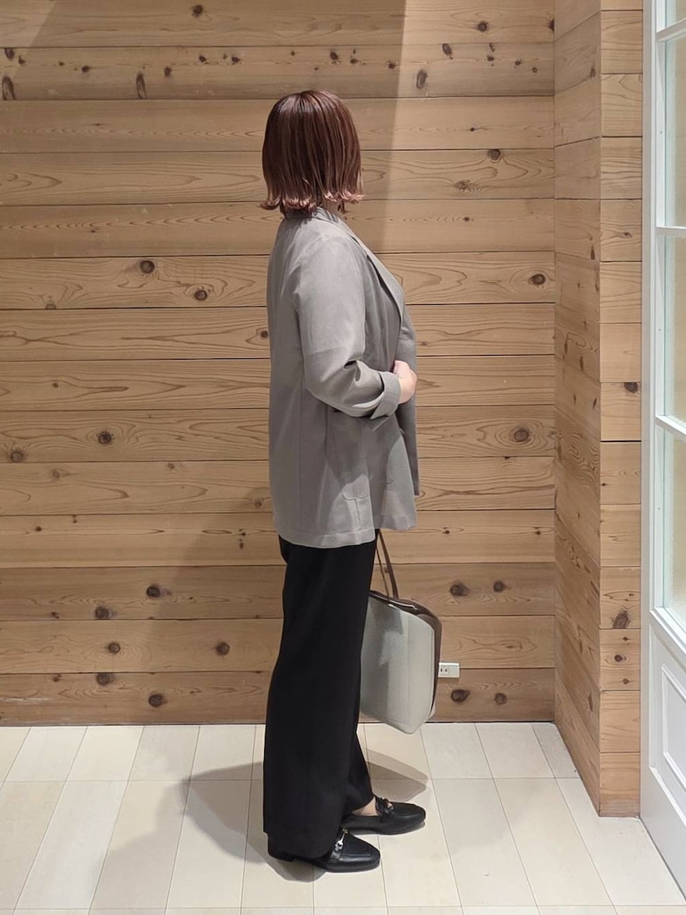 ブラック系のローファー、ホワイト系のトートバッグ、ホワイト系のTシャツ/カットソーを着用したレディースの春コーディネートの2枚目の写真