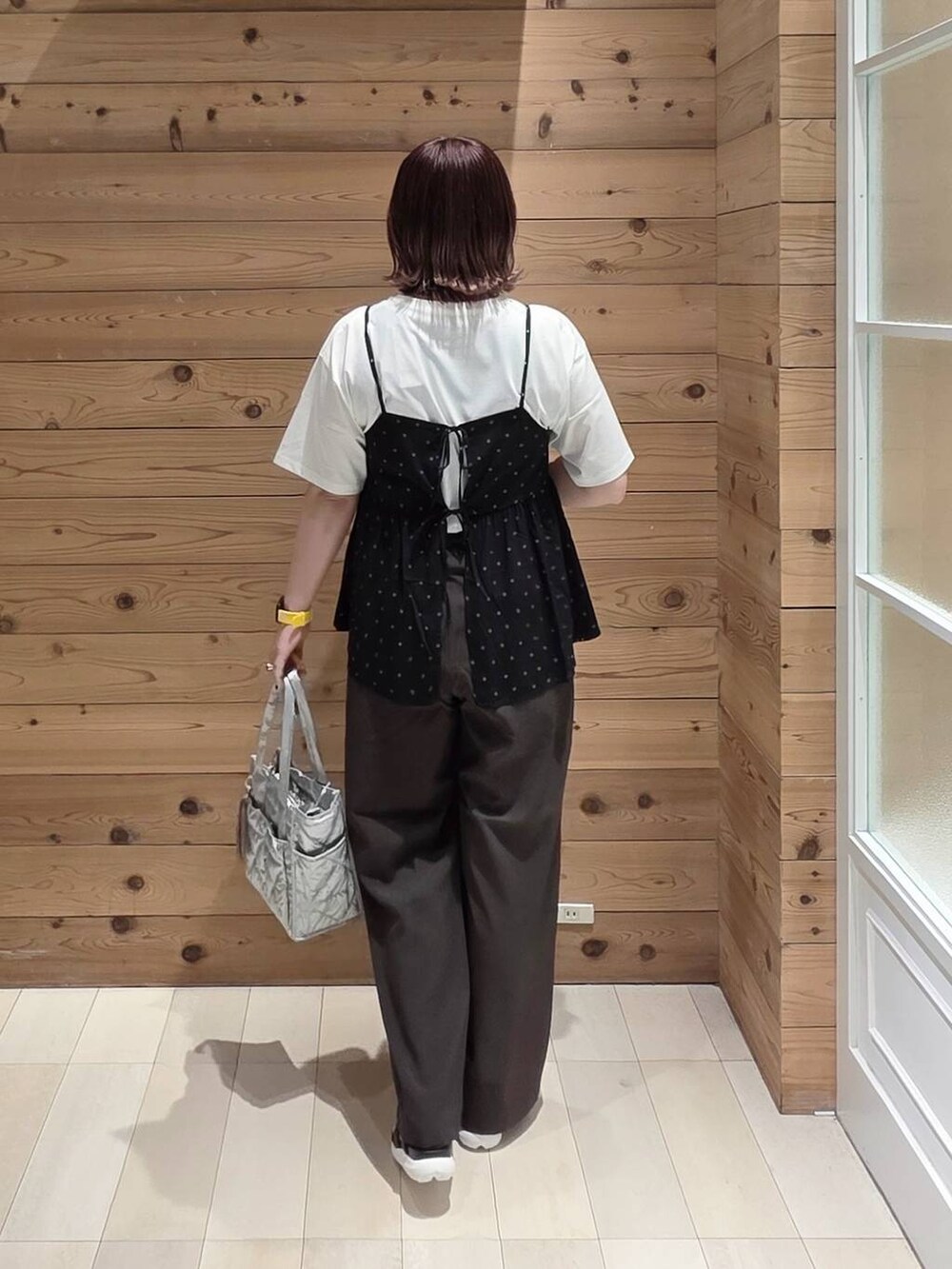 シルバー系のトートバッグ、ブラウン系のその他パンツ、ブラック系のその他パンツを着用したレディースの春コーディネートの3枚目の写真