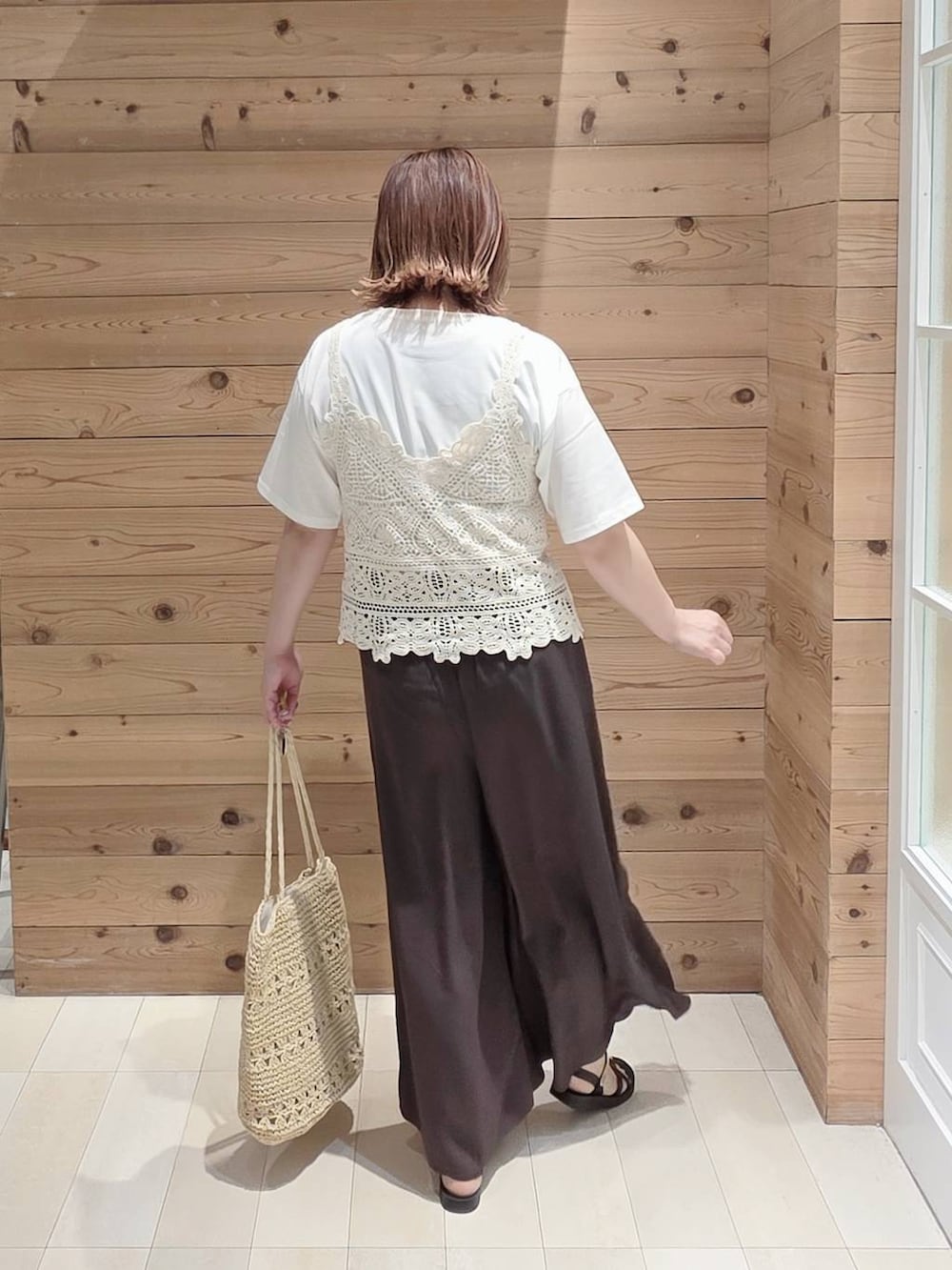 ブラウン系のその他パンツ、ホワイト系のTシャツ/カットソー、ベージュ系のトートバッグを着用したレディースの夏コーディネートの3枚目の写真