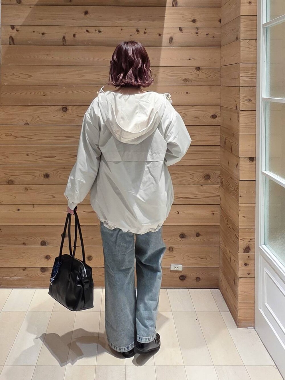 ブラック系のローファー、ブラック系のボストンバッグ、ブルー系のデニムパンツを着用したレディースの冬コーディネートの3枚目の写真