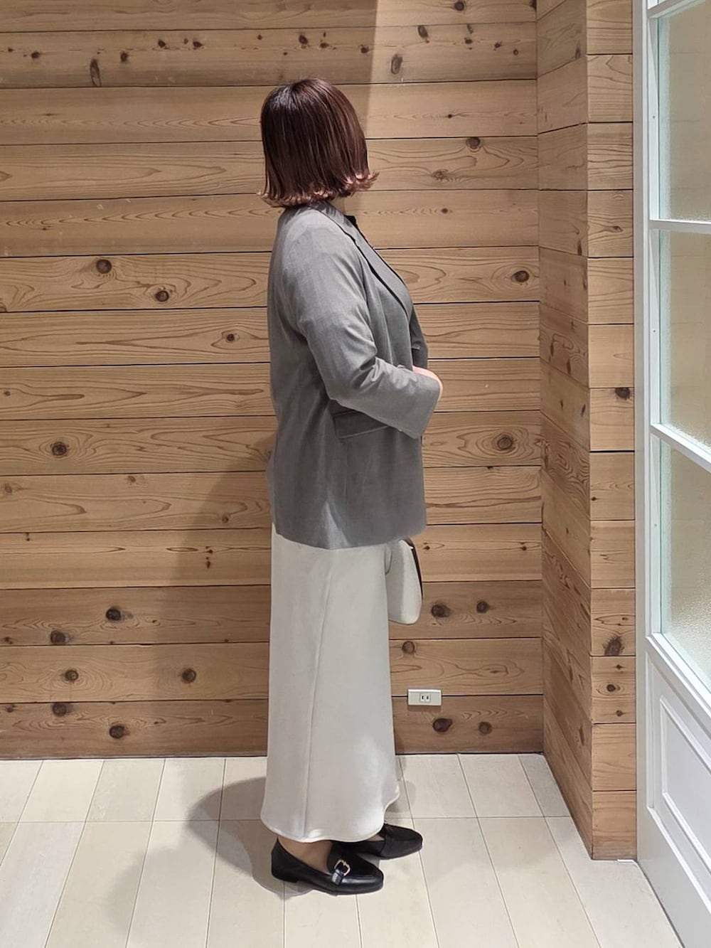 ブラック系のローファー、ホワイト系のショルダーバッグ、ブラック系のTシャツ/カットソーを着用したレディースの冬コーディネートの2枚目の写真