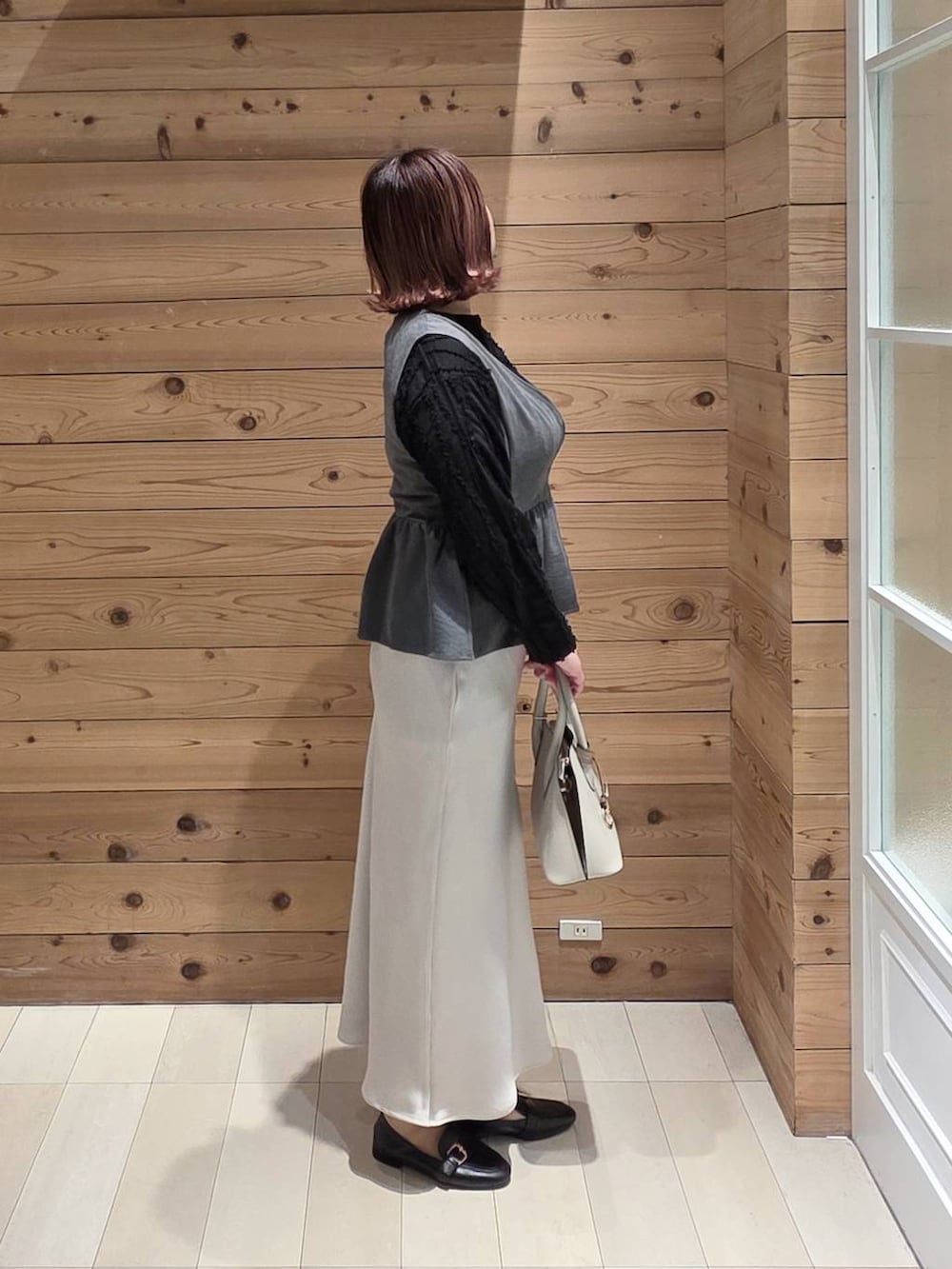 ブラック系のローファー、ホワイト系のショルダーバッグ、ブラック系のTシャツ/カットソーを着用したレディースの冬コーディネートの2枚目の写真