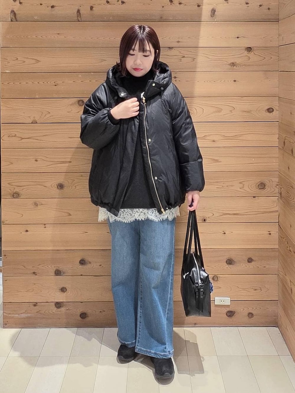 ブラック系のダウンジャケット/コート、ブラック系のボストンバッグ、ブラック系のブーツを着用したレディースの冬コーディネートの4枚目の写真