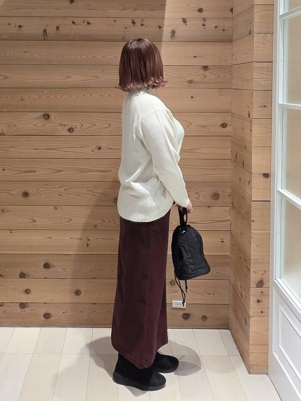 その他のチェスターコート、レッド系のスカート、ブラック系のハンドバッグを着用したレディースの冬コーディネートの2枚目の写真