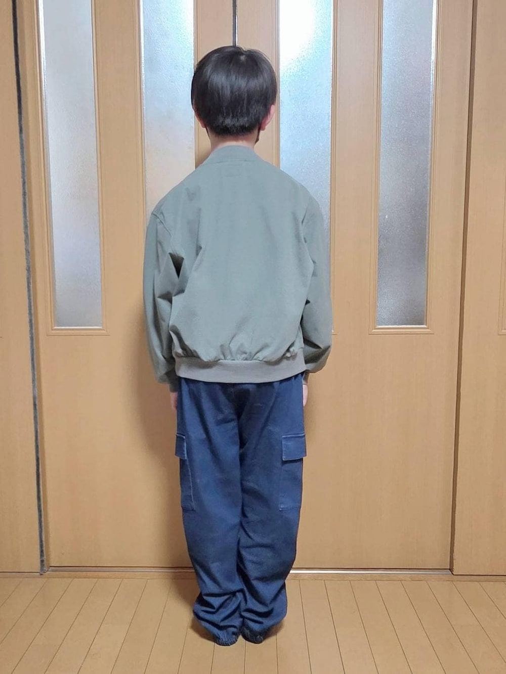 ブルー系のカーゴパンツ、グリーン系のMA-1、ブルー系のTシャツ/カットソーを着用したキッズの春コーディネートの3枚目の写真