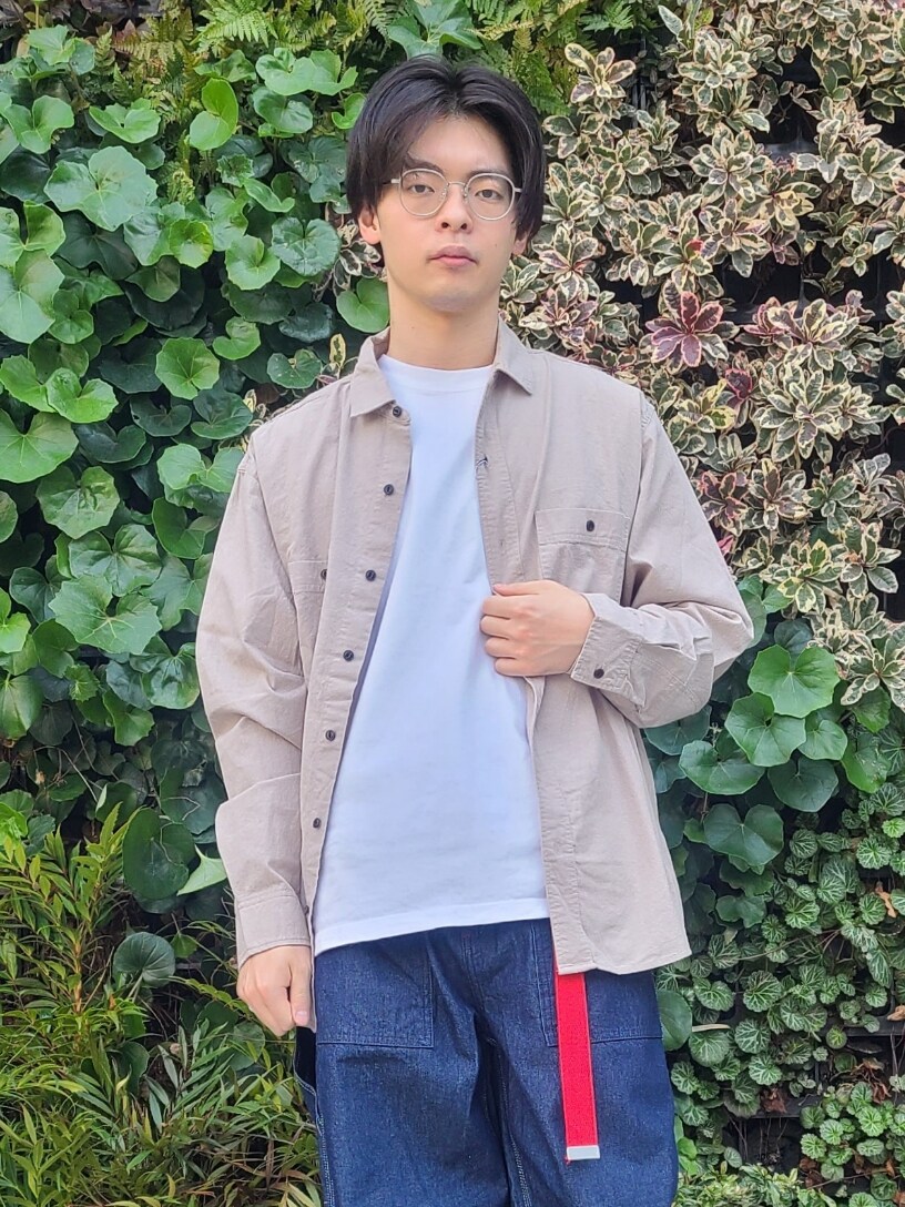 ベージュ系のトップス、ブルー系のデニムパンツ、ホワイト系のスニーカーを着用したメンズの春コーディネートの2枚目の写真