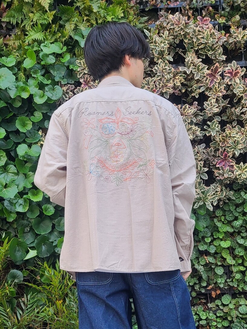ベージュ系のトップス、ブルー系のデニムパンツ、ホワイト系のスニーカーを着用したメンズの春コーディネートの3枚目の写真