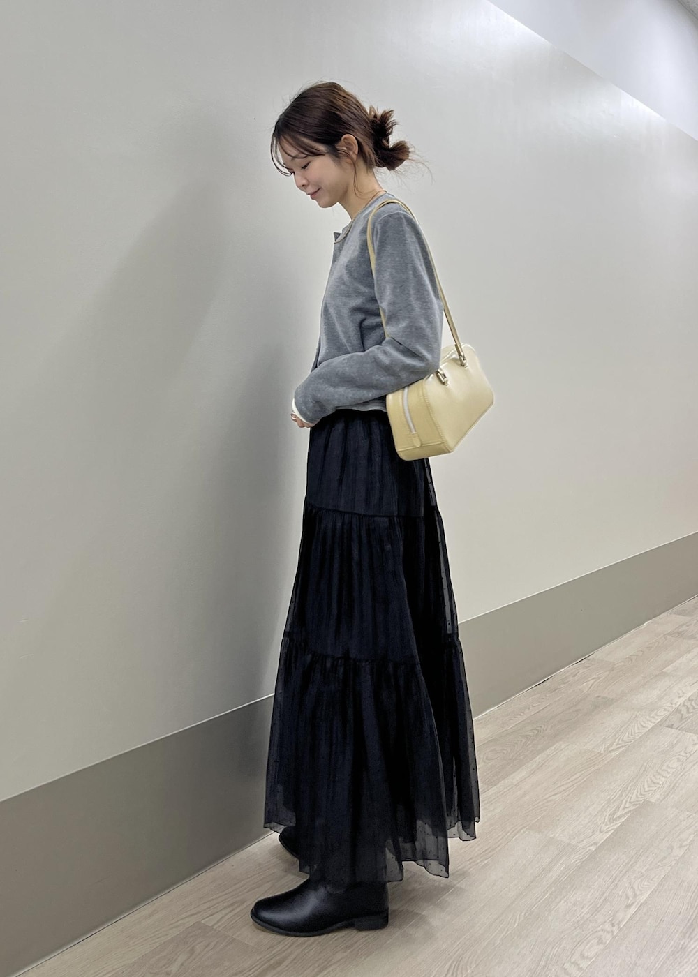 ホワイト系のTシャツ/カットソー、ブラック系のブーツ、グレー系のカーディガン/ボレロを着用したレディースの秋コーディネートの5枚目の写真