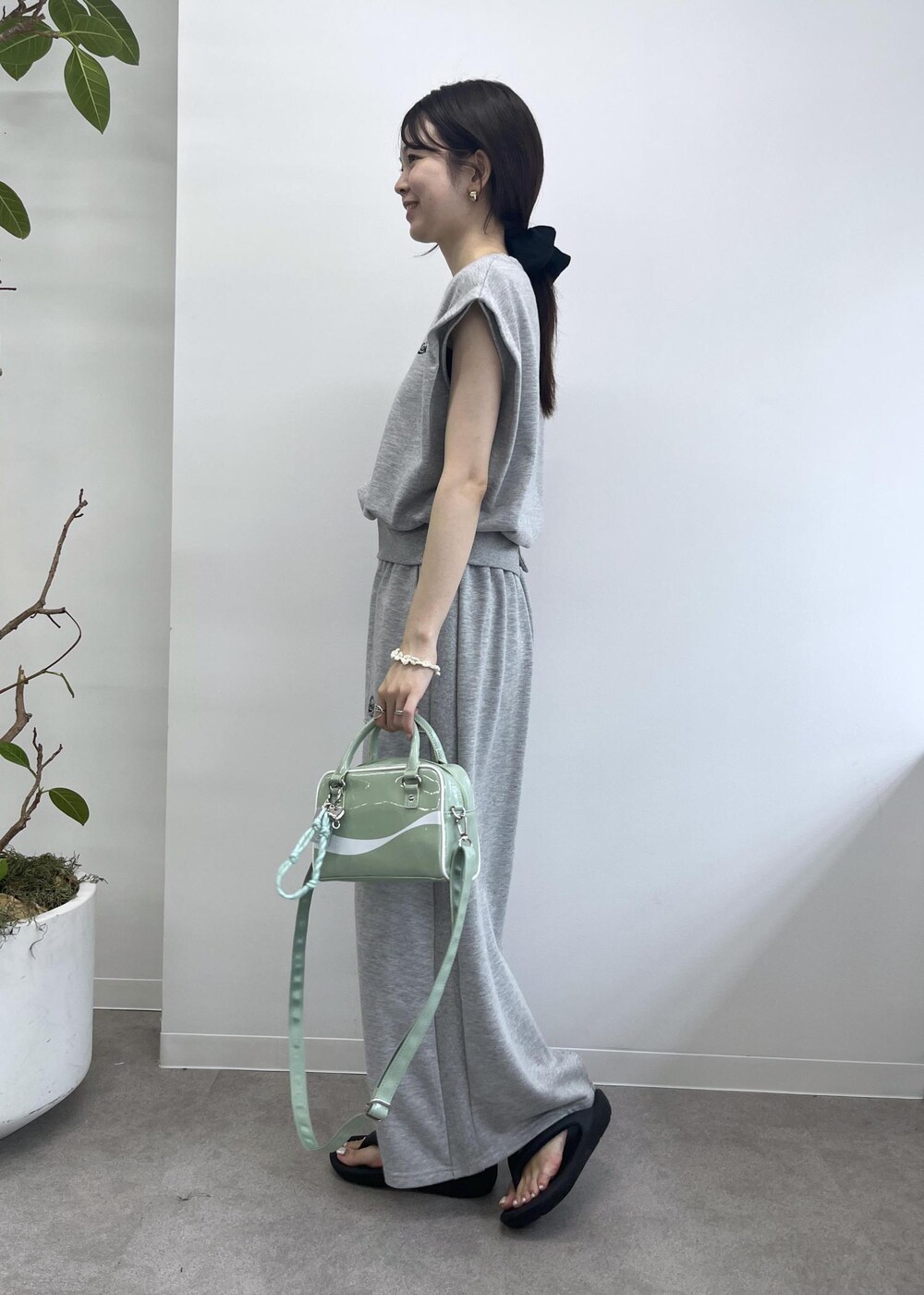 グレー系のスカート、グレー系のTシャツ/カットソー、グリーン系のボストンバッグを着用したレディースの夏コーディネートの3枚目の写真