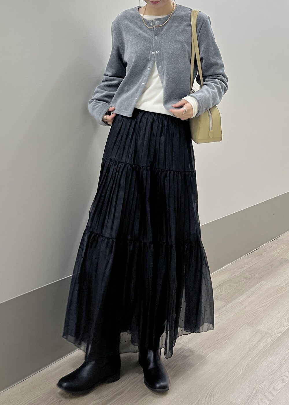 ホワイト系のTシャツ/カットソー、ブラック系のブーツ、グレー系のカーディガン/ボレロを着用したレディースの秋コーディネートの4枚目の写真