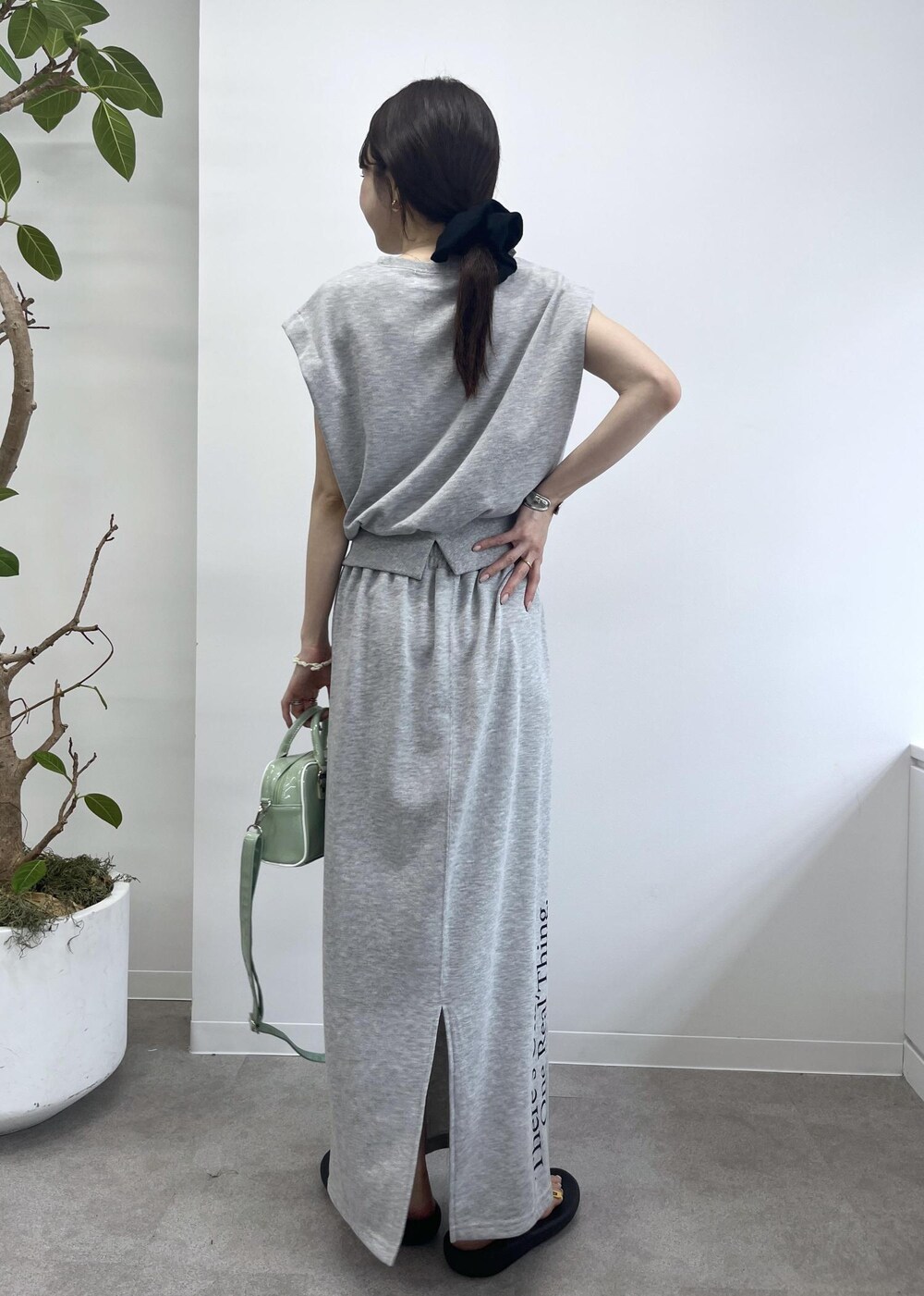 グレー系のスカート、グレー系のTシャツ/カットソー、グリーン系のボストンバッグを着用したレディースの夏コーディネートの5枚目の写真