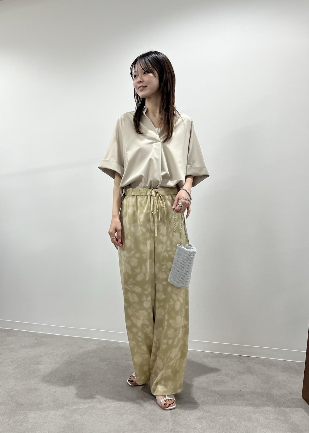 ベージュ系のその他パンツ、シルバー系のパンプス、その他のショルダーバッグを着用したレディースの春コーディネートの2枚目の写真