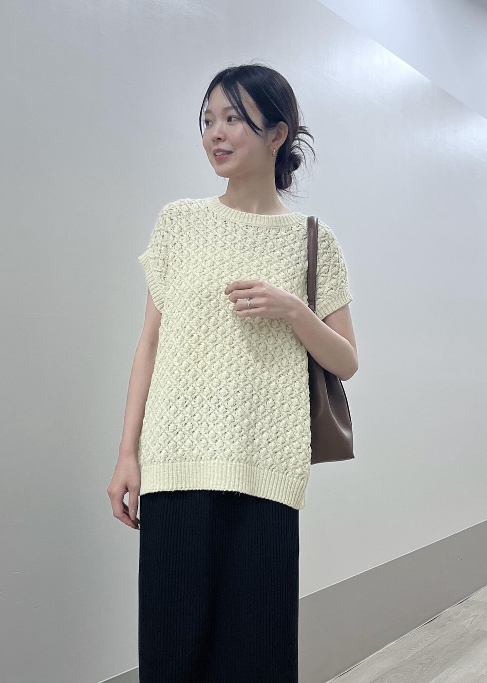ブラック系のスカート、ベージュ系のベスト、ブラウン系のショルダーバッグを着用したレディースの夏コーディネートの6枚目の写真