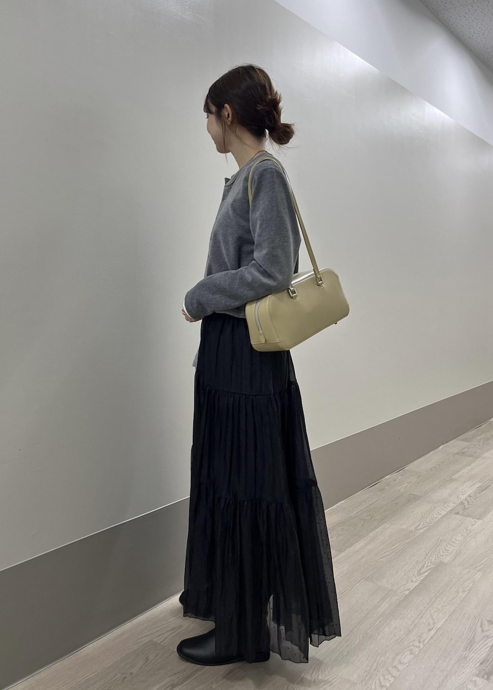 ホワイト系のTシャツ/カットソー、ブラック系のブーツ、グレー系のカーディガン/ボレロを着用したレディースの秋コーディネートの6枚目の写真