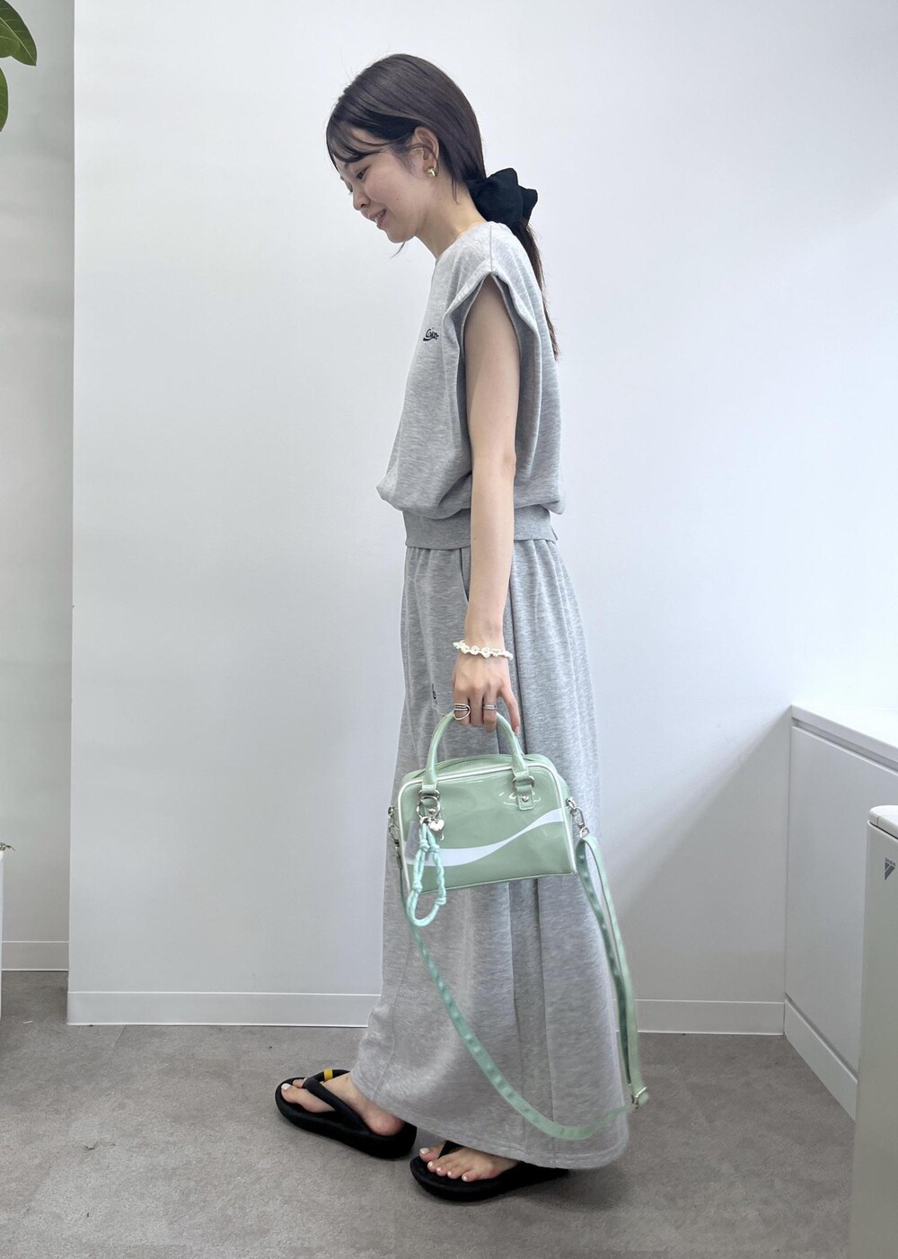 グレー系のスカート、グレー系のTシャツ/カットソー、グリーン系のボストンバッグを着用したレディースの夏コーディネートの4枚目の写真