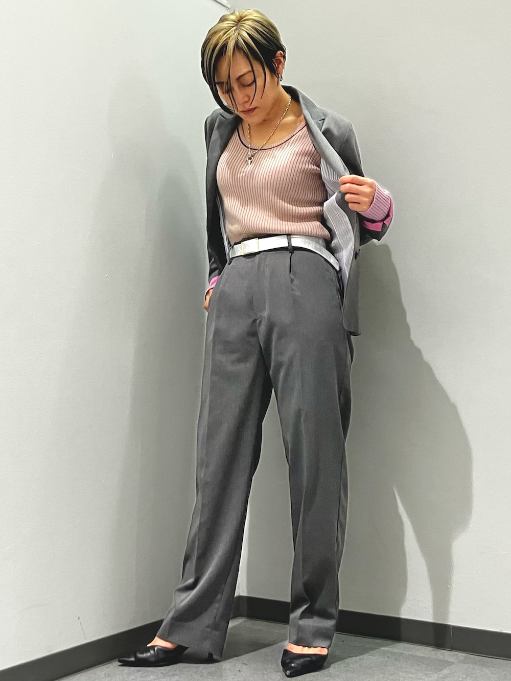 ピンク系のニット/セーター、グレー系のテーラードジャケット、グレー系のスラックスを着用したレディースの秋コーディネートの2枚目の写真