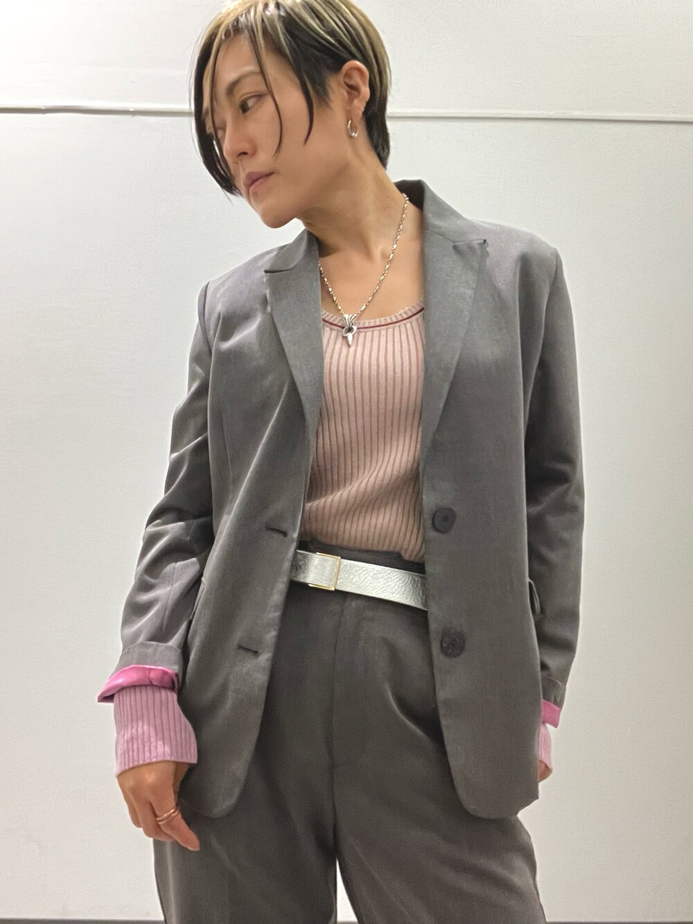 ピンク系のニット/セーター、グレー系のテーラードジャケット、グレー系のスラックスを着用したレディースの秋コーディネートの3枚目の写真