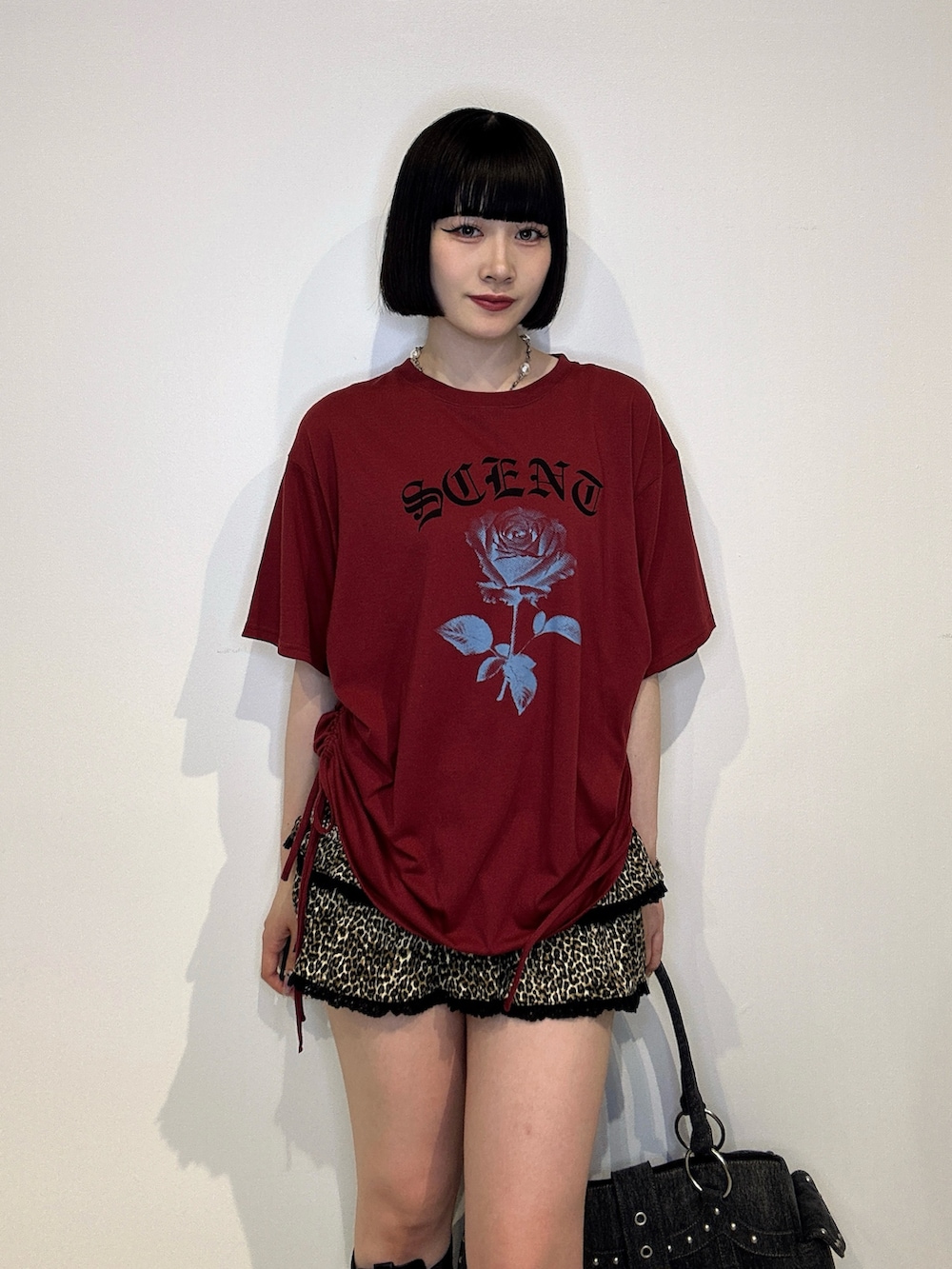 レッド系のTシャツ/カットソー、ブラウン系のスカート、ブラック系のブーツを着用したレディースの夏コーディネートの5枚目の写真