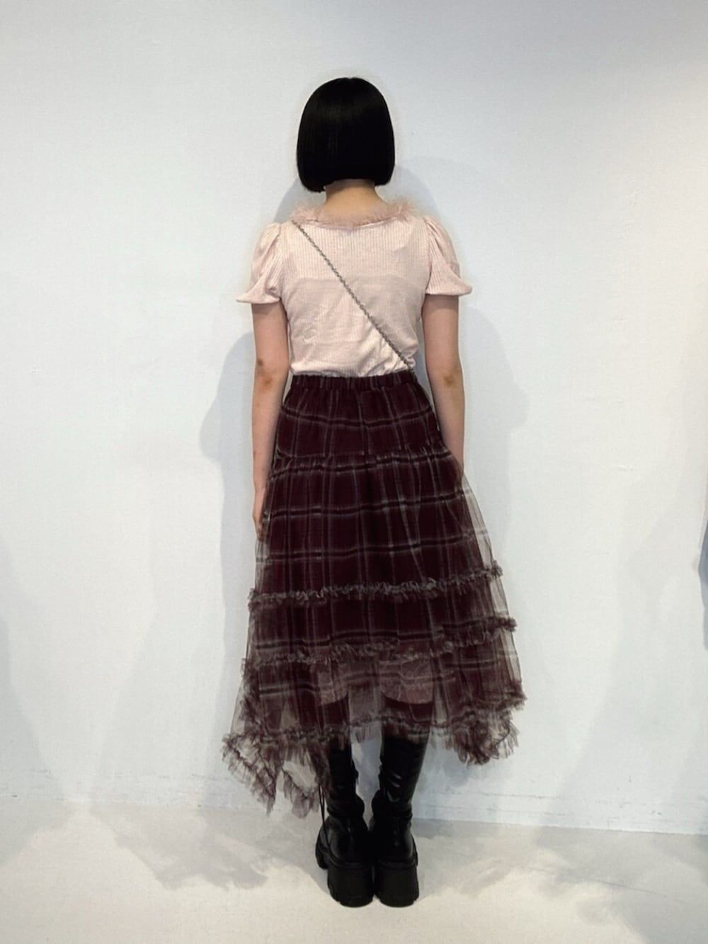 レッド系のスカート、ピンク系のTシャツ/カットソー、ブラック系のブーツを着用したレディースの夏コーディネートの3枚目の写真