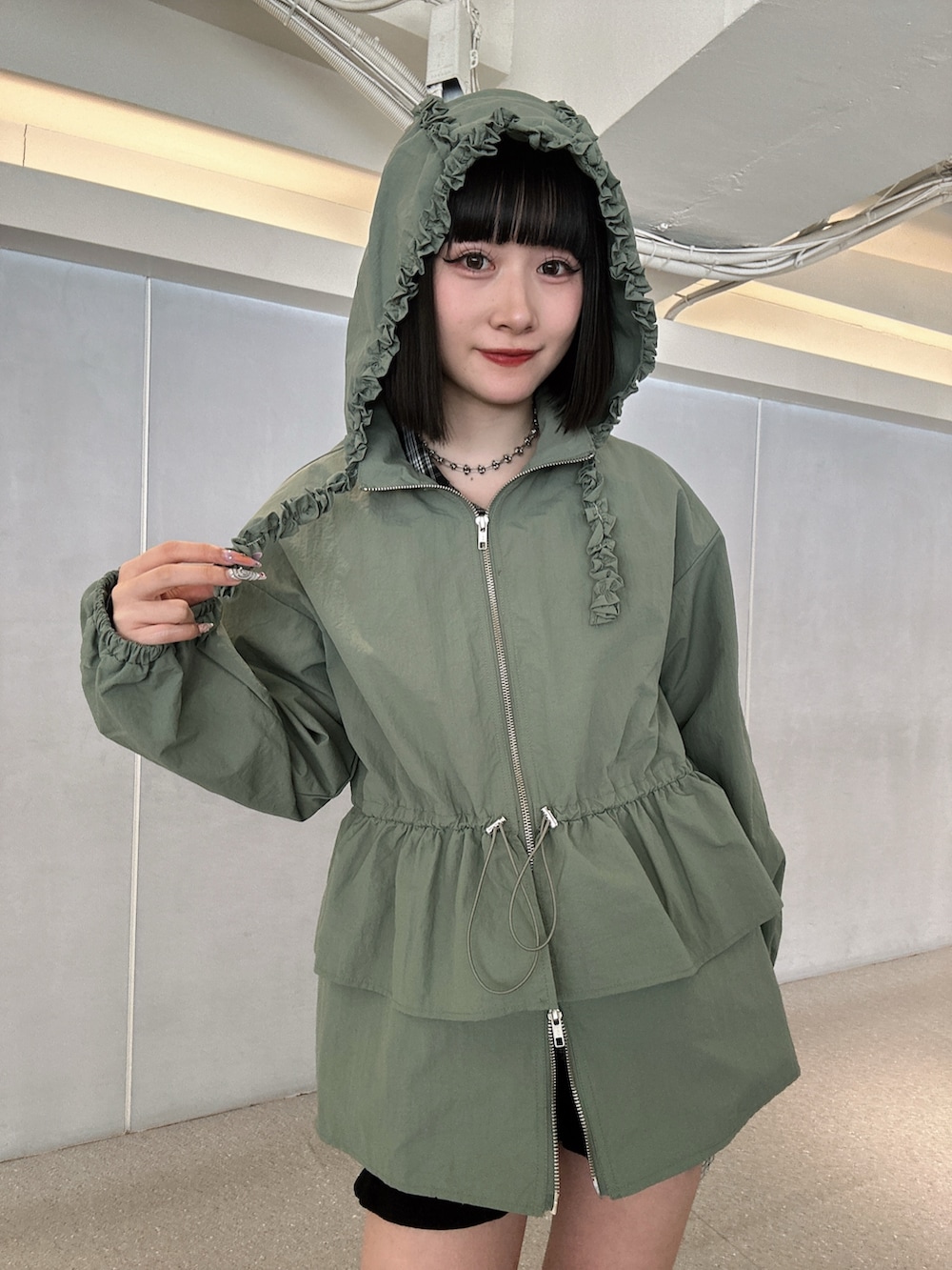 グリーン系のナイロンジャケット、ブラック系のローファー、ブラック系のその他パンツを着用したレディースの春コーディネートの4枚目の写真