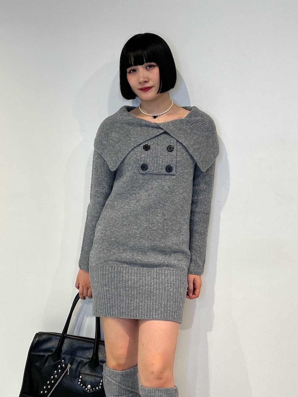 グレー系のワンピース、ブラック系のハンドバッグ、ブラック系のサンダルを着用したレディースの秋コーディネートの4枚目の写真