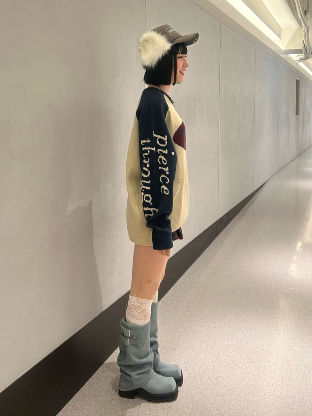 ホワイト系のニット/セーター、ブルー系のスカート、ブルー系のブーツを着用したレディースの秋コーディネートの2枚目の写真