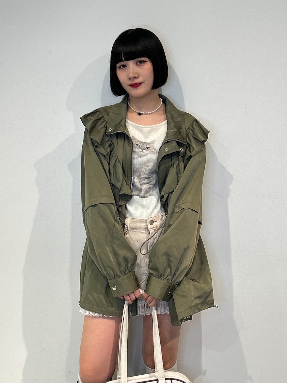 ベージュ系のブルゾン、ホワイト系のTシャツ/カットソー、ベージュ系のデニムスカートを着用したレディースの秋コーディネートの4枚目の写真