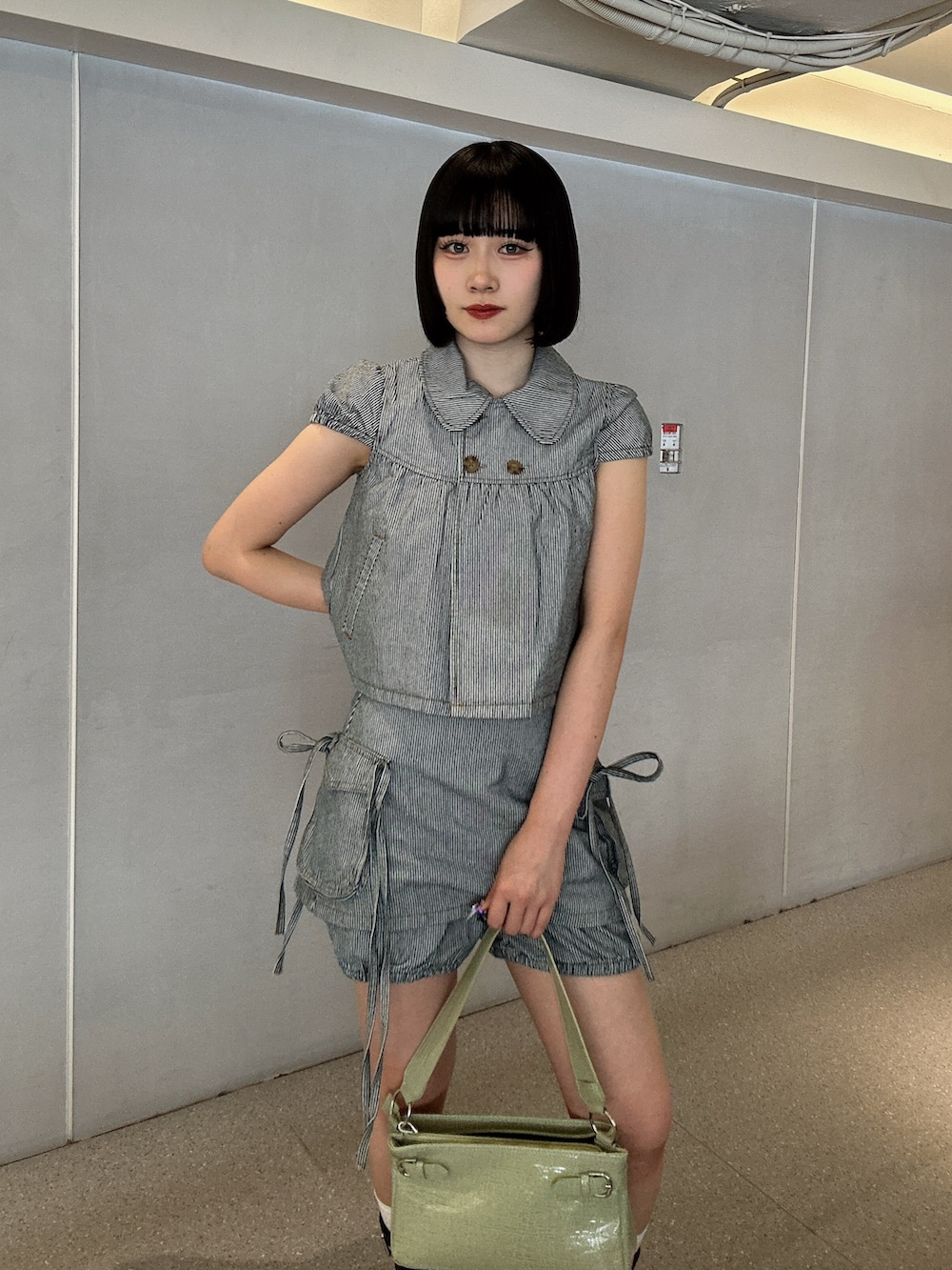 ブラック系のその他トップス、ブラック系のデニムパンツ、グリーン系のハンドバッグを着用したレディースの春コーディネートの4枚目の写真