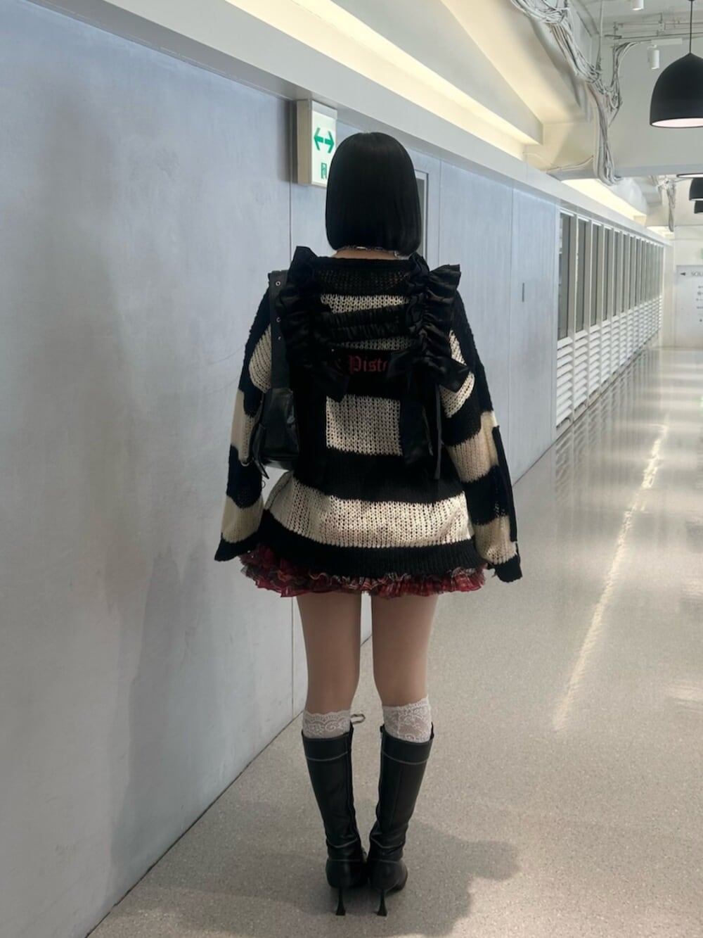 その他のニット/セーター、ブラック系のブーツ、レッド系のスカートを着用したレディースの秋コーディネートの4枚目の写真