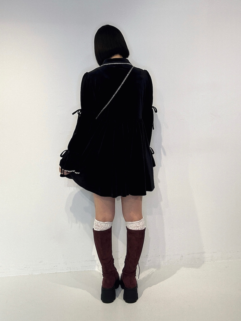 ブラック系のワンピース、レッド系のブーツ、ブラック系のショルダーバッグを着用したレディースの夏コーディネートの3枚目の写真